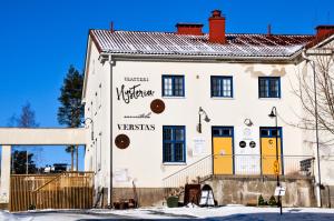 ein weißes Gebäude mit gelben und orangefarbenen Türen in der Unterkunft Hostel Bjorkenheim in Seinäjoki