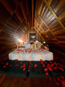 two people sitting in a bed with roses on the floor at Chalé do Beijo in Nazaré Paulista