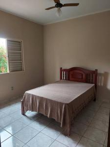 um quarto com uma cama e uma ventoinha de tecto em Rancho Tamanduá em Passos