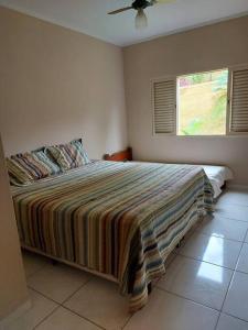 um quarto com uma cama grande e uma janela em Rancho Tamanduá em Passos