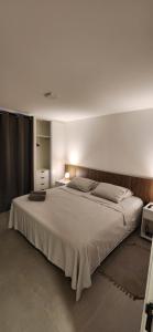 - une chambre avec un grand lit blanc dans l'établissement Flat Moderno Pé na Areia no Cumbuco Piscina e Localização Perfeitas Eco Paradise, à Caucaia