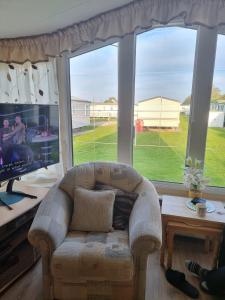 a living room with a couch and a large window at Summerlands, Ingoldmells 8 berth caravan in Skegness