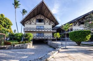a building with palm trees in front of it at Go Eco Paradise Ap210 Pé na Areia e Piscina no Centro do Cumbuco in Caucaia