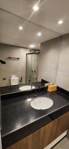 une salle de bains avec deux lavabos et un grand miroir dans l'établissement Flat Moderno Pé na Areia no Cumbuco Piscina e Localização Perfeitas Eco Paradise, à Caucaia