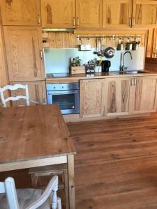 a kitchen with wooden cabinets and a wooden table at Cabane de Pêcheurs Huraia in Vielle-Saint-Girons +6 photos