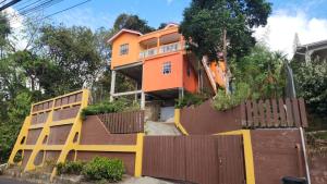 an orange house with a fence in front of it at ZionGates in Castries