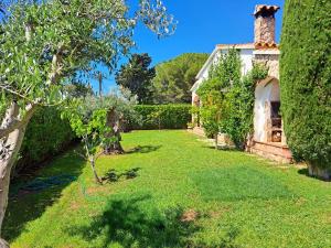 einen Garten mit grünem Gras und ein Haus in der Unterkunft Casa en Viladamat con piscina en la Costa Brava in Viladamat