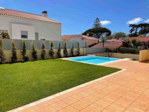 um quintal com uma cerca e uma piscina em Admiral House Estoril em Estoril