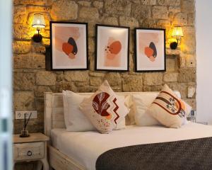 a bedroom with a bed with four pictures on the wall at Lulja Alaçatı - Adults Only in Izmir