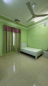 um quarto com uma cama e uma ventoinha de tecto em الجبل الاخضر سيق ( بيت الصوير ) em Sayq