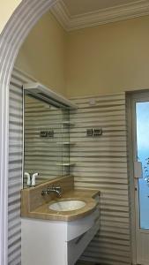 uma casa de banho com um lavatório e um espelho em الجبل الاخضر سيق ( بيت الصوير ) em Sayq