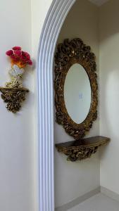 einen Spiegel an einer Wand mit einem Regal und einer Vase in der Unterkunft الجبل الاخضر سيق ( بيت الصوير ) in Sayq