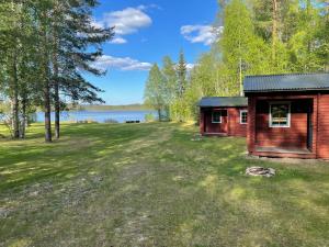 a small cabin in the grass next to a lake at Steiner's Camping & Lodge in Johannisholm