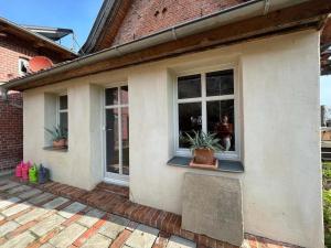 uma casa com duas janelas e dois vasos de plantas em Erholung zu Zweit 
