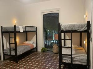 Dos literas en una habitación con ventana. en Choco Hostel, en Puebla