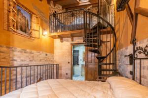a bedroom with a bed and a spiral staircase at Apartamento divino morales in Plasencia