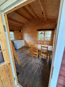 comedor en una cabaña de madera con mesa y sillas en Steiner's Camping & Lodge en Johannisholm