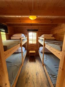 a room with three bunk beds in a cabin at Steiner's Camping & Lodge in Johannisholm