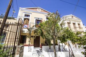 a white house with trees in front of it at Symi Center Hotel in Symi