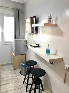 a kitchen with two stools and a counter with a refrigerator at New elegant Studio in the center of Thessaloniki in Thessaloniki