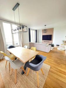 - un salon avec une table et des chaises en bois dans l'établissement Appartement chaleureux proche Paris JO 2024, à Saint-Gratien