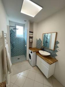 La salle de bains est pourvue d'un lavabo et d'un lave-linge. dans l'établissement Appartement chaleureux proche Paris JO 2024, à Saint-Gratien