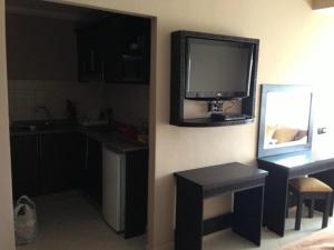 a kitchen with a tv on the wall and a table at lovly imssounae appartment in Imsouane