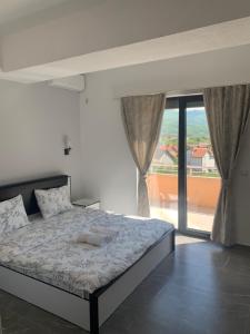 1 dormitorio con cama y ventana grande en Hotel Albatros, en Prizren