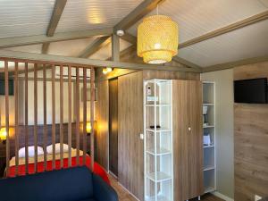 een kamer met een wieg, een bed en een televisie bij Camping Dolce Vita in Calvi