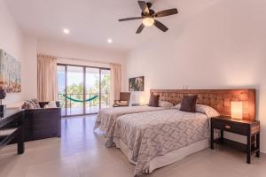 - une chambre avec un lit et un ventilateur de plafond dans l'établissement Villa Bellamar : A dream beachfront spot near Tulum with Chef Service included, à Akumal