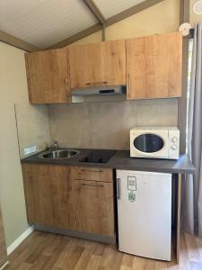 a small kitchen with a microwave and a sink at Camping Dolce Vita in Calvi