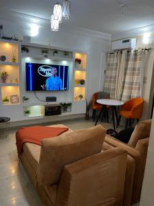1bed luxury Apartment Opebi في إيكيجا: غرفة معيشة مع أريكة وتلفزيون بشاشة مسطحة
