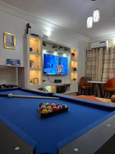 un soggiorno con tavolo da biliardo e TV di 1bed luxury Apartment Opebi a Ikeja