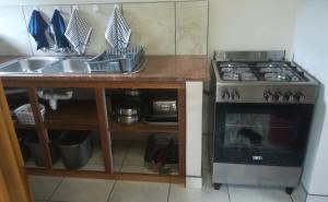 a kitchen with a sink and a stove at Die Uil Nes Self Catering Accommodation in Gouritzmond