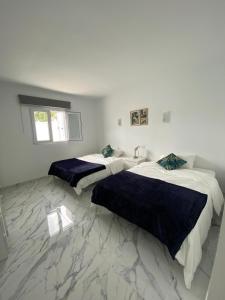 two beds in a room with white walls and marble floors at Villa Cecilia, Maspalomas (Nuevo a estrenar) in Maspalomas +17 photos