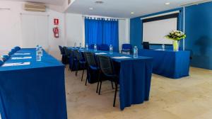 Hotel Aeropuerto Sur في سان إيسيذرو: قاعة المؤتمرات مع الطاولات والكراسي الزرقاء
