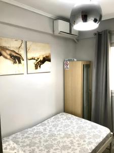 a bedroom with three paintings on the wall and a bed at New elegant Studio in the center of Thessaloniki in Thessaloniki