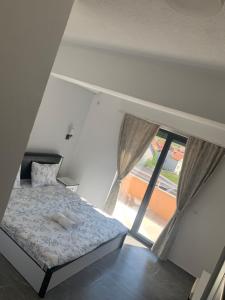 a bedroom with a bed and a large window at Hotel Albatros in Prizren