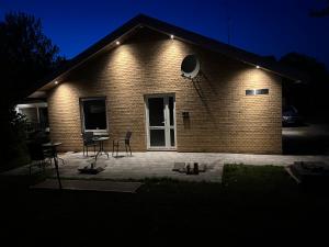a brick house with a patio at night at SleepOver in Rødby! Few minutes from Femern Tunnel and Ferry to Puttgarden in Rødby
