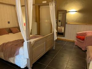 1 dormitorio con cama con dosel y espejo en Quarter House en Damme