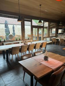 a dining room with tables and chairs and windows at Quarter House in Damme