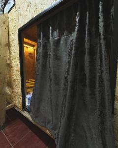 a window with a black curtain in a room at Хата - капсульный отель, хостел in Akbulak