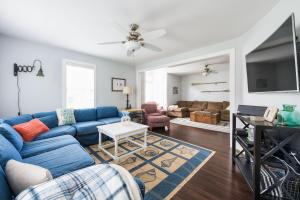 a living room with a blue couch and a tv at Summer Haven- Walk to beach & Town from this 4 bedroom 2 bath Coastal Cottage in South Haven