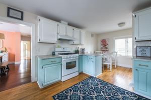 a kitchen with blue cabinets and a dining room at Summer Haven- Walk to beach & Town from this 4 bedroom 2 bath Coastal Cottage in South Haven