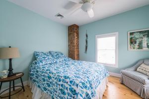 a blue bedroom with a bed and a couch at Summer Haven- Walk to beach & Town from this 4 bedroom 2 bath Coastal Cottage in South Haven