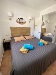 - une chambre avec un grand lit et des serviettes bleues dans l'établissement Apartment Casa Lieja - Cumbre del Sol, à Cumbre del Sol