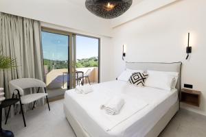 ein weißes Schlafzimmer mit einem großen Bett und einem Balkon in der Unterkunft We Summer in Dassia