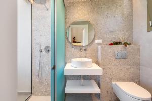 ein Badezimmer mit Waschbecken, Toilette und Spiegel in der Unterkunft We Summer in Dassia + 22 Fotos