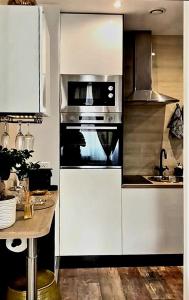 a kitchen with stainless steel appliances and a table at Denis&kanya in Nice