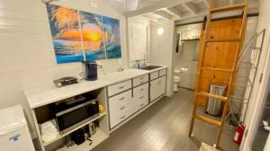 una cocina con fregadero y una gran pintura en la pared en Tiny Home #1 at Blue Eyes Park, en Bolivar Peninsula